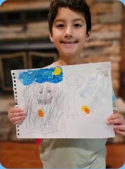 A boy holding up his drawing