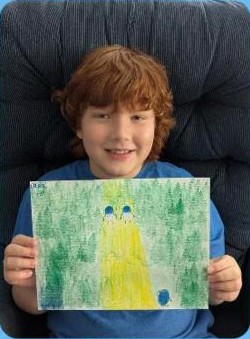 A boy holding up his drawing