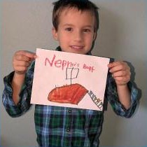 A boy holding up his drawing of Nephi's boat