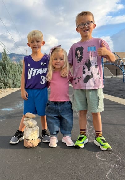 Three kids standing together outside