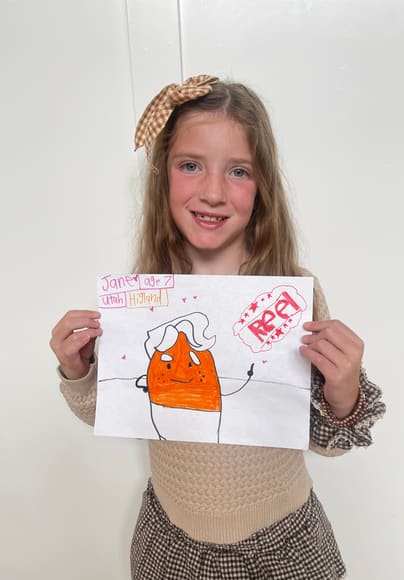 A girl holding up her drawing