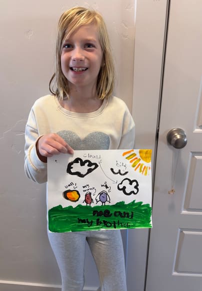 A girl holding up her drawing